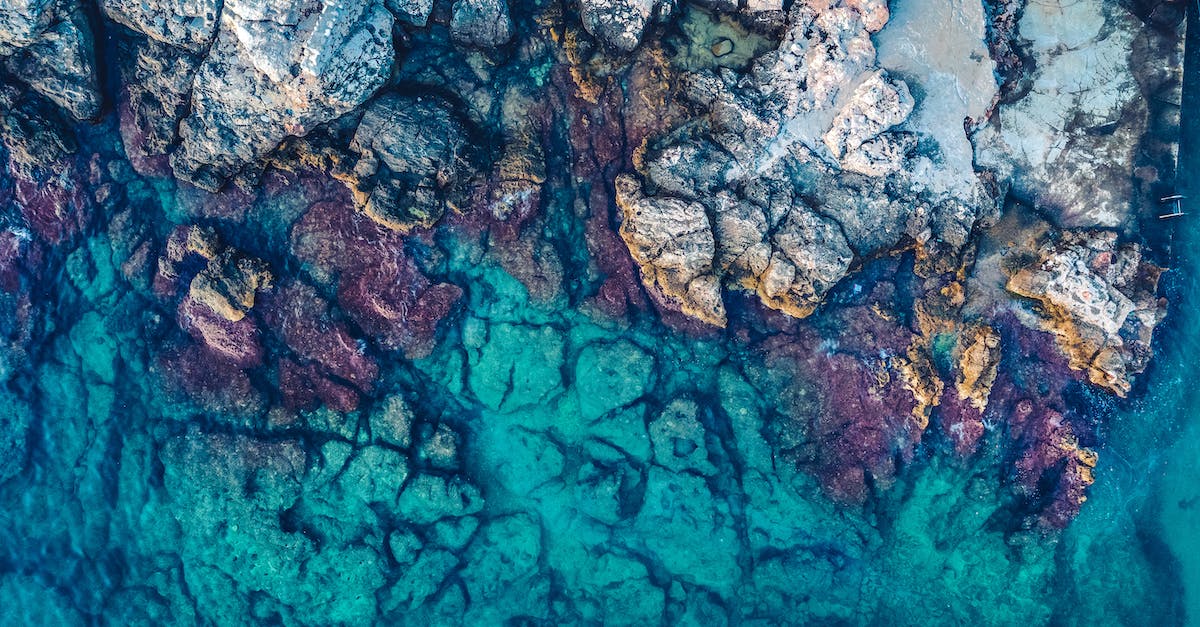 aerial-photography-of-rocks-beside-body-of-water-9920308