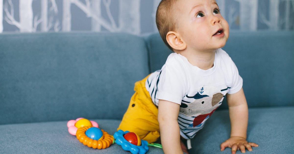 baby-in-blue-and-white-t-shirt-and-gray-shorts-sitting-on-blue-textile-7970491