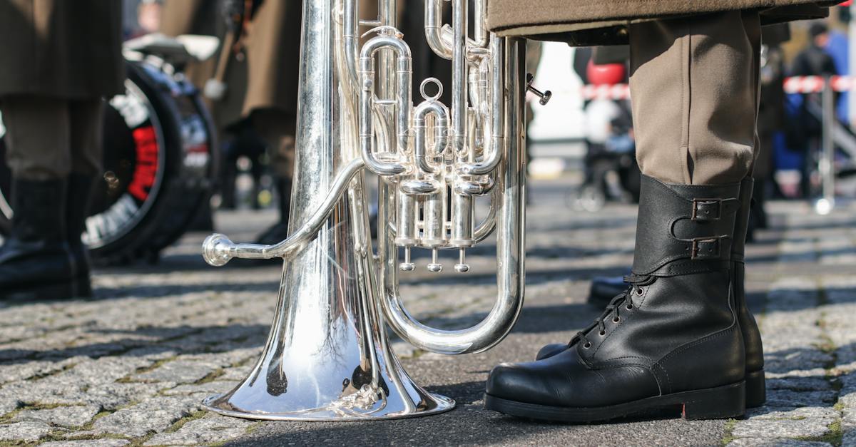 brass-trumpet-on-grey-concrete-floor-beside-a-person-wearing-black-leather-boots-4175595