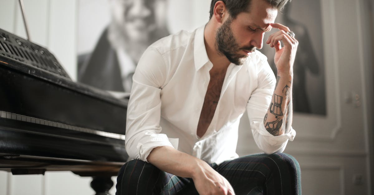 dramatic-tattooed-male-sitting-at-piano-9103449