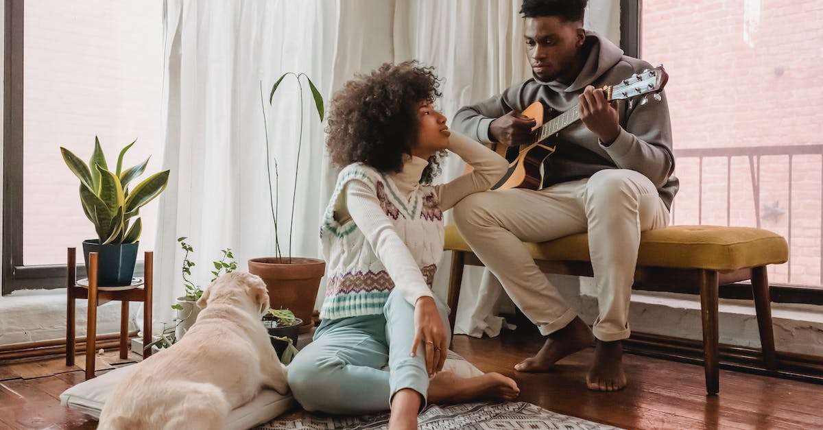 full-body-of-black-boyfriend-playing-acoustic-guitar-for-african-american-girlfriend-while-spending-5279204