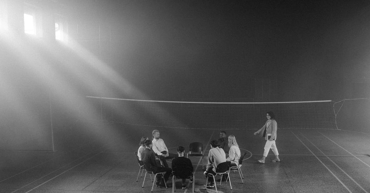 grayscale-photo-of-people-sitting-on-the-chairs-5308858