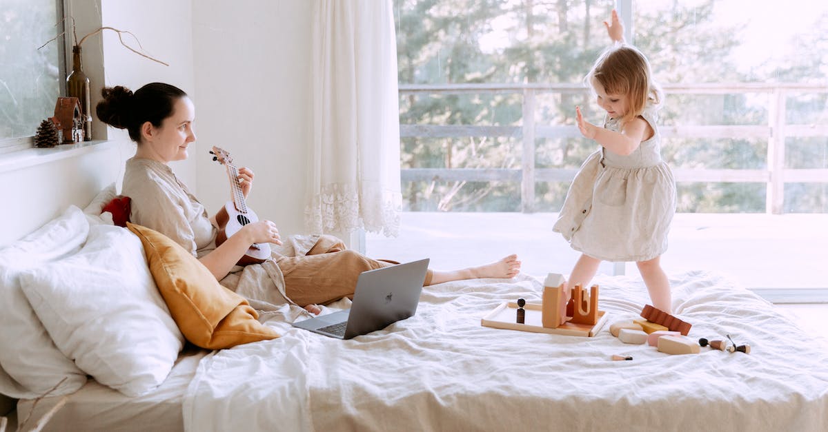 happy-young-woman-playing-ukulele-for-daughter-at-home-1543268
