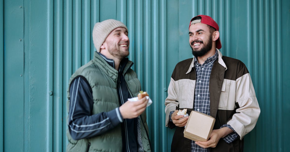 man-in-green-jacket-holding-white-box-2601600