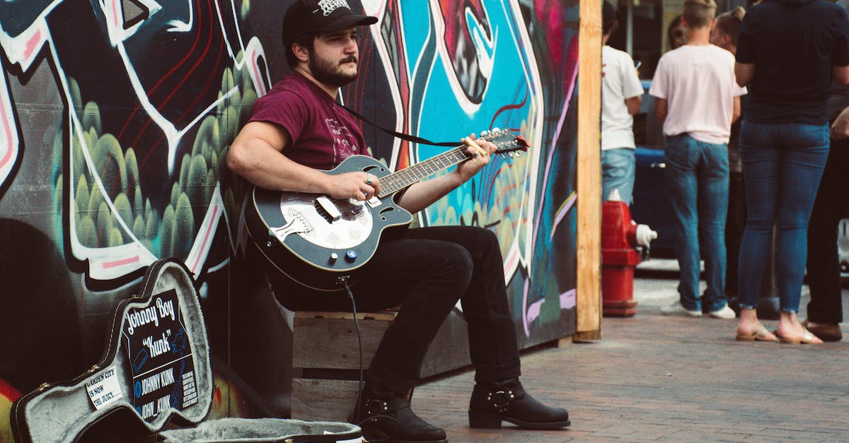 man-playing-black-cutaway-guitar-6031844