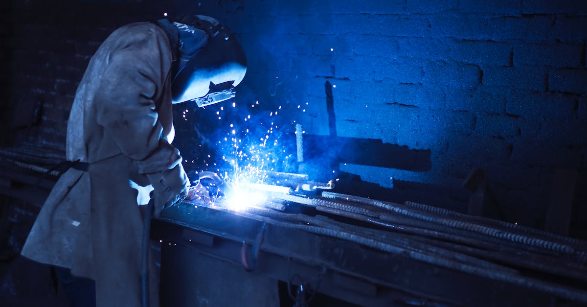 man-wearing-welding-helmet-welding-metal-near-gray-brick-wall-1730053