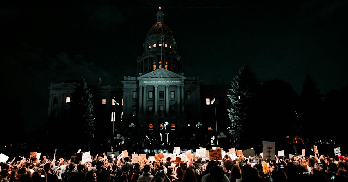 people-rallying-in-front-of-white-building-during-nightime-7890968