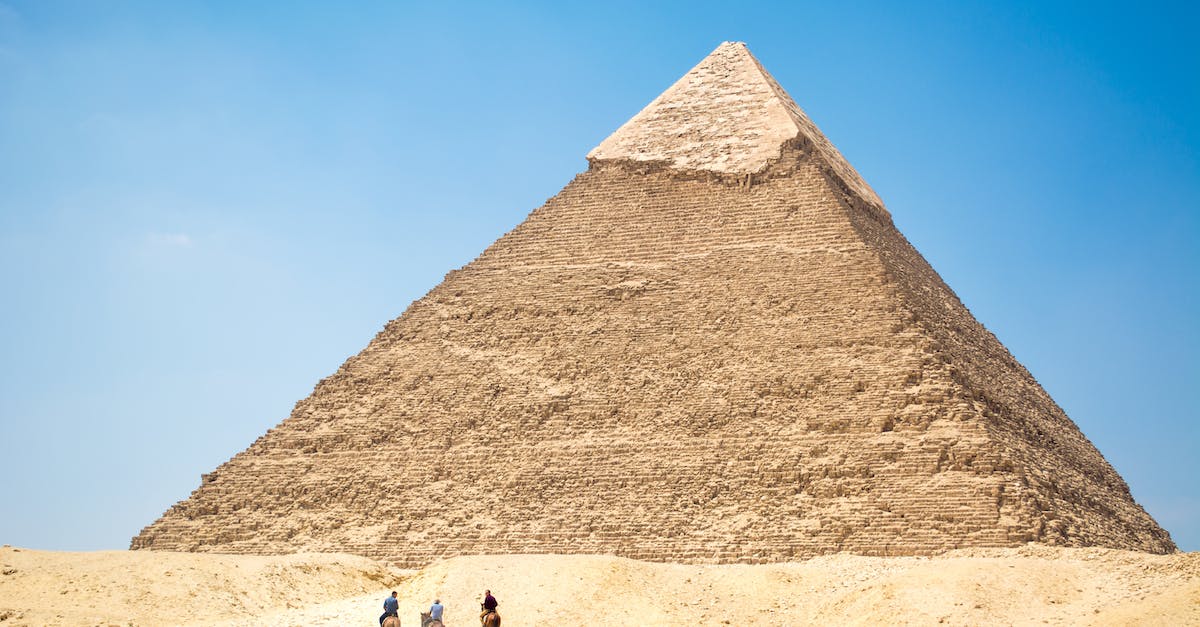people-riding-a-camel-near-pyramid-under-blue-sky-6129600