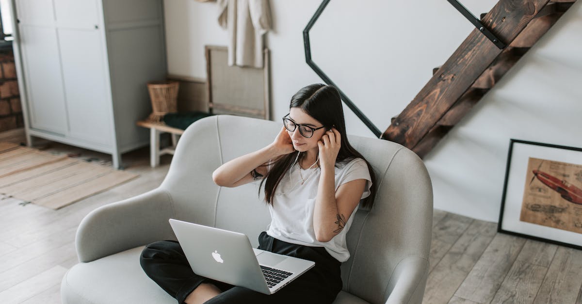 positive-woman-using-earphones-and-laptop-at-home-during-free-time-7511493