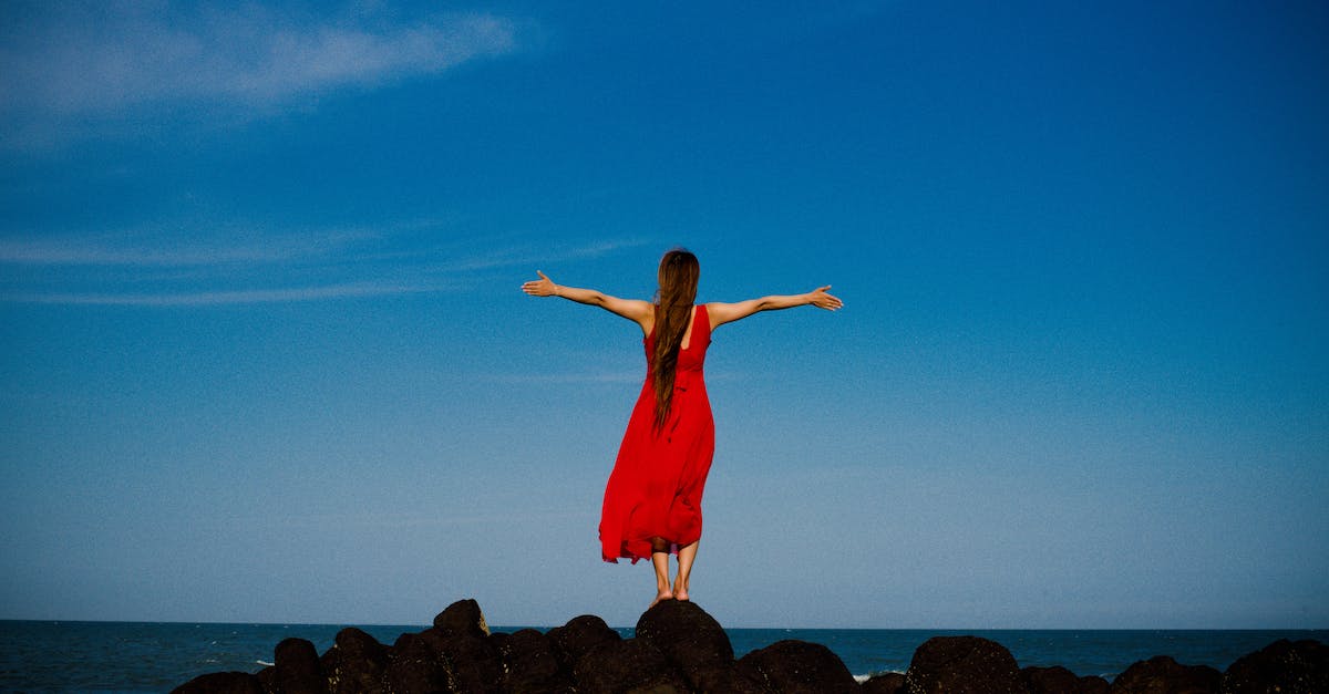 unrecognizable-woman-standing-on-rocky-seashore-5304576