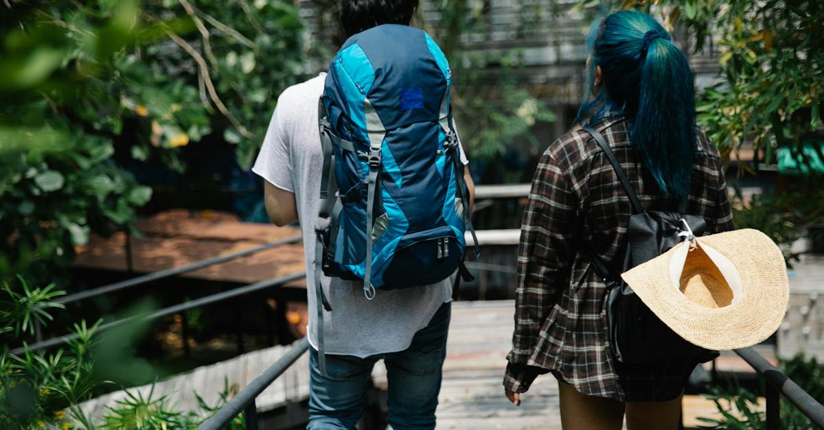 unrecognizable-young-couple-walking-on-footbridge-in-green-park-8810539