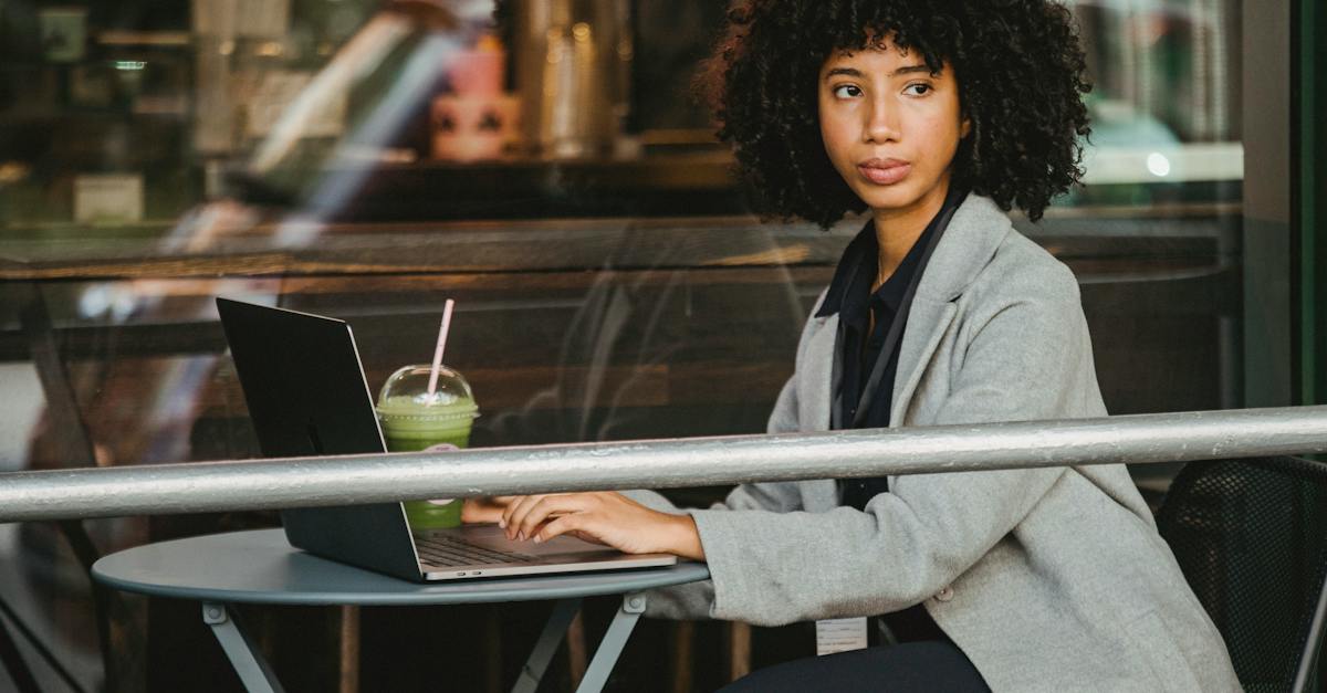 woman-in-gray-blazer-sitting-near-glass-window-9570248