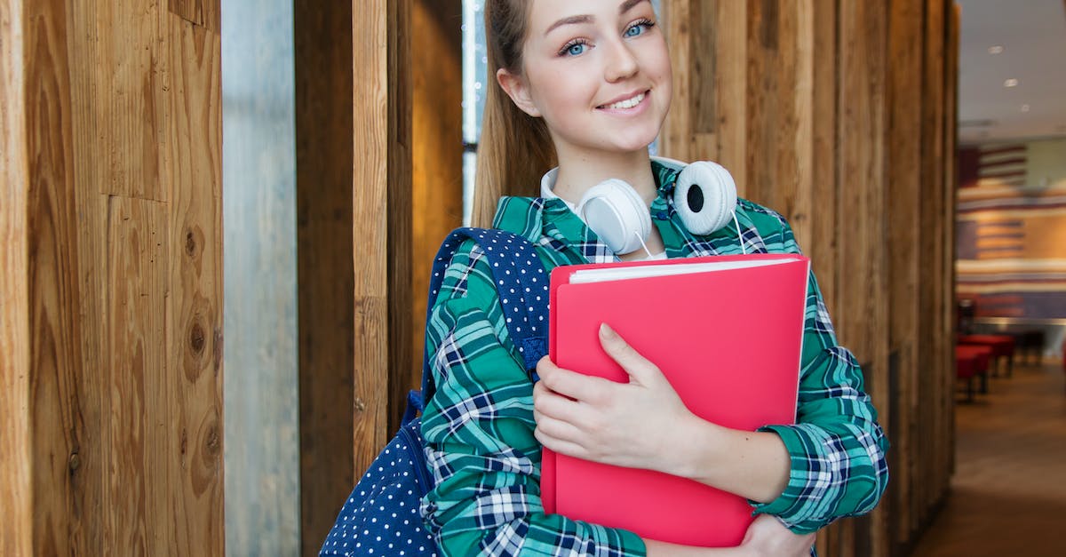 woman-standing-in-hallway-while-holding-book-2017396